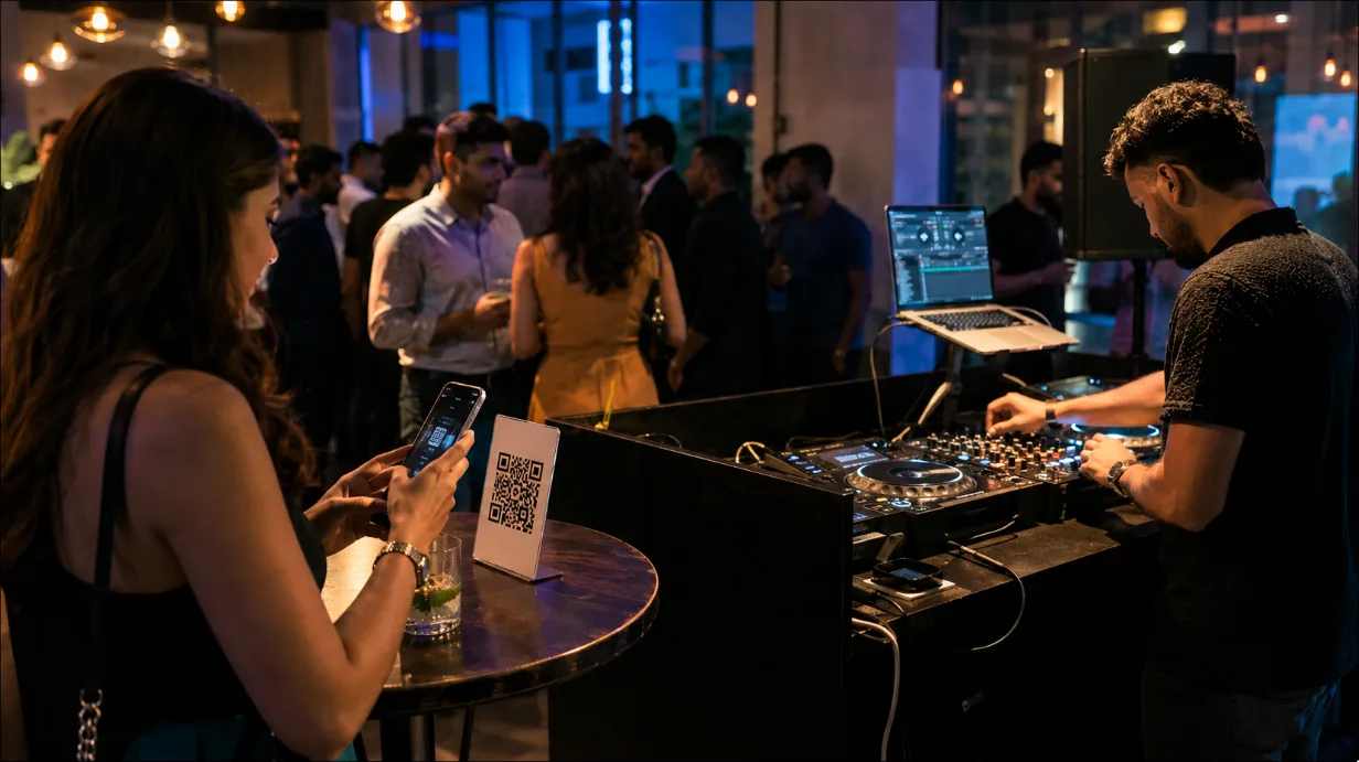 A vibrant event setting showing a DJ focused on their software while a guest scans a QR code on a nearby table.